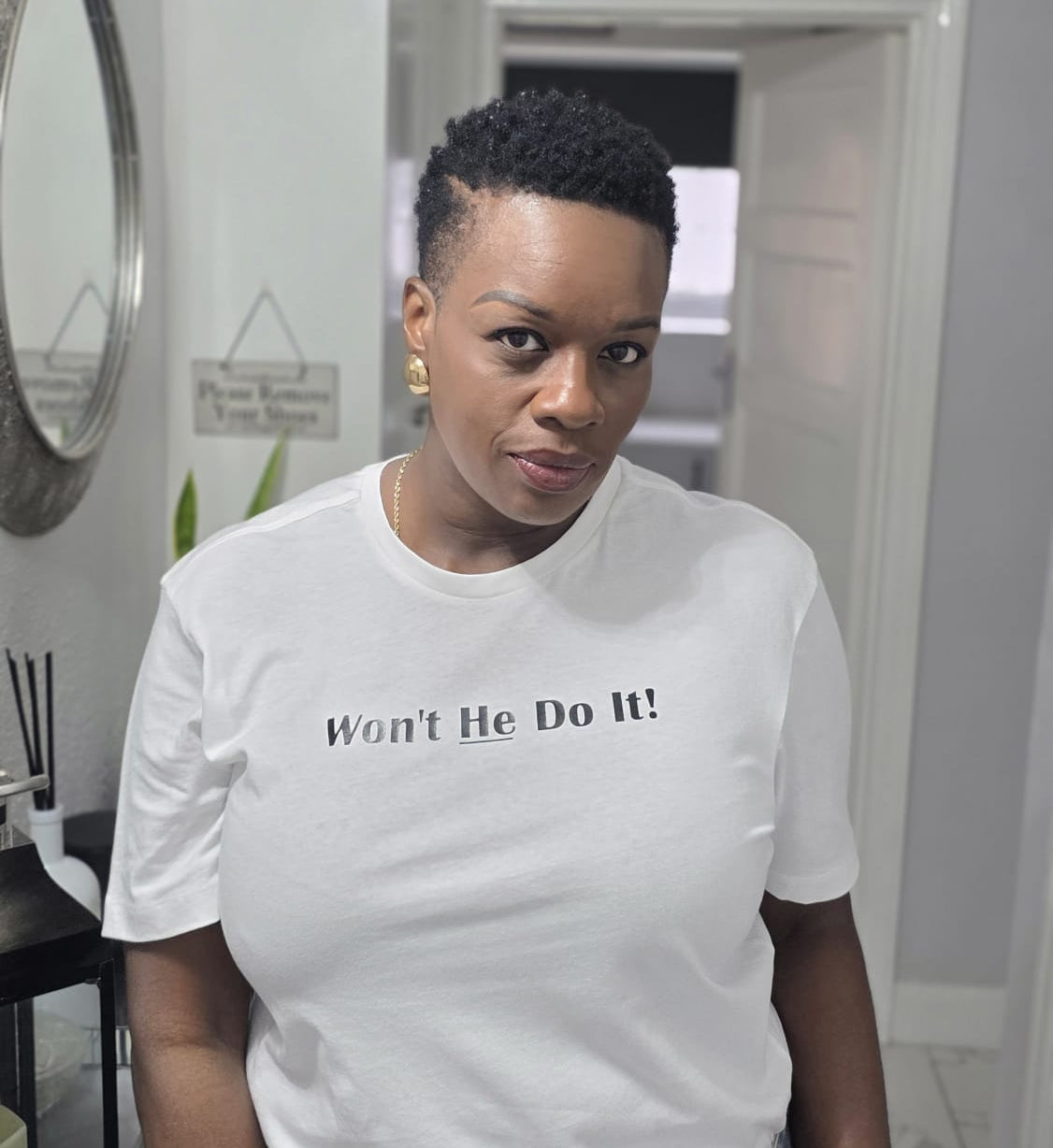Person wearing a white t-shirt with text in a home setting